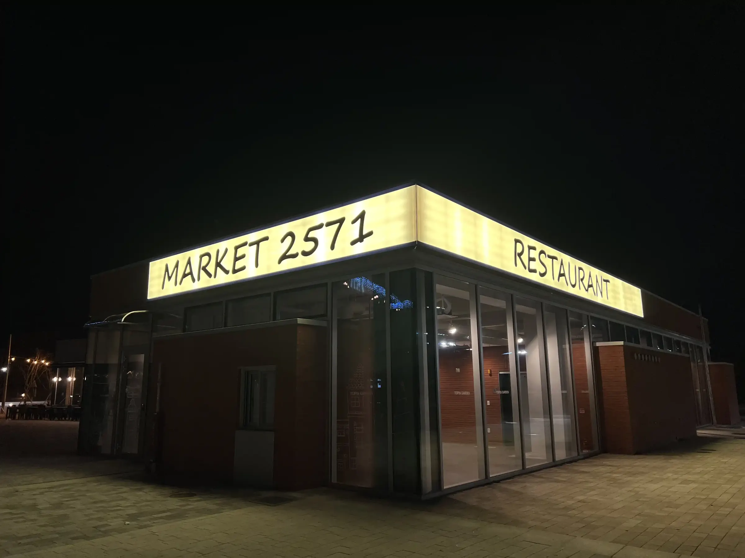 밤에 간판이 환하게 켜진 MARKET 2571 붉은 벽돌 건물